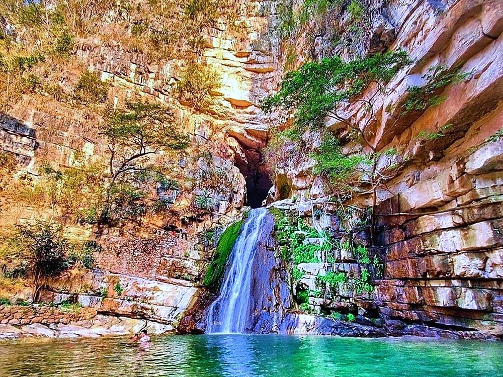 The El Chorreadero waterfall falling from a cave mouth into a turquoise pool, Chiapas, Mexico